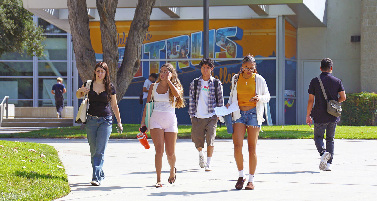 students walk across a sunny campus walkway in front of a citrus college mural, carrying bags, water bottles and class materials