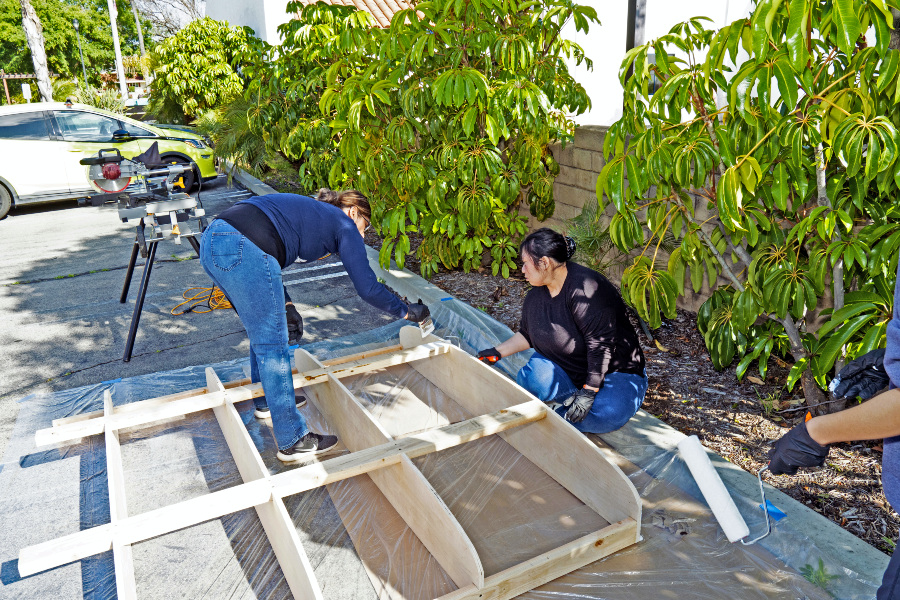 students work on a wooden trailer frame for a citrus college architecture club shower project