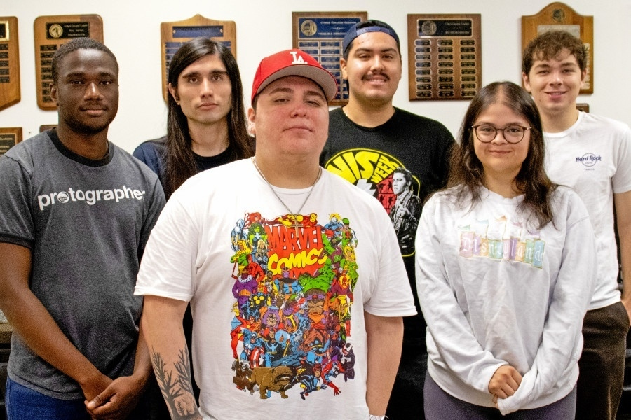 clarion student journalists gather for a group photo in front of campus journalism award plaques