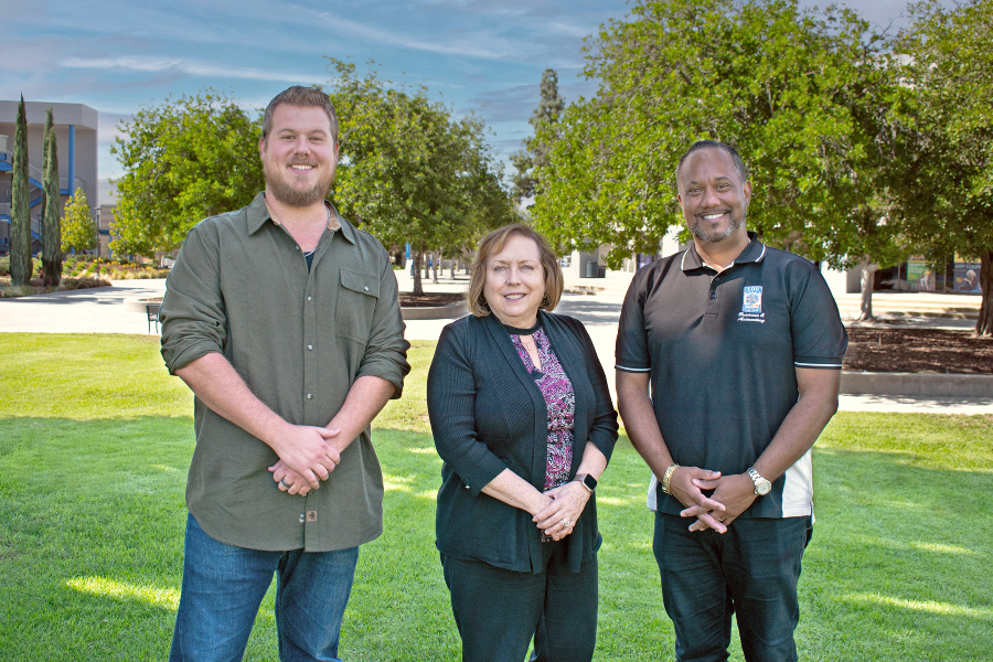 three citrus college real estate faculty members stand together on campus near trees and grass