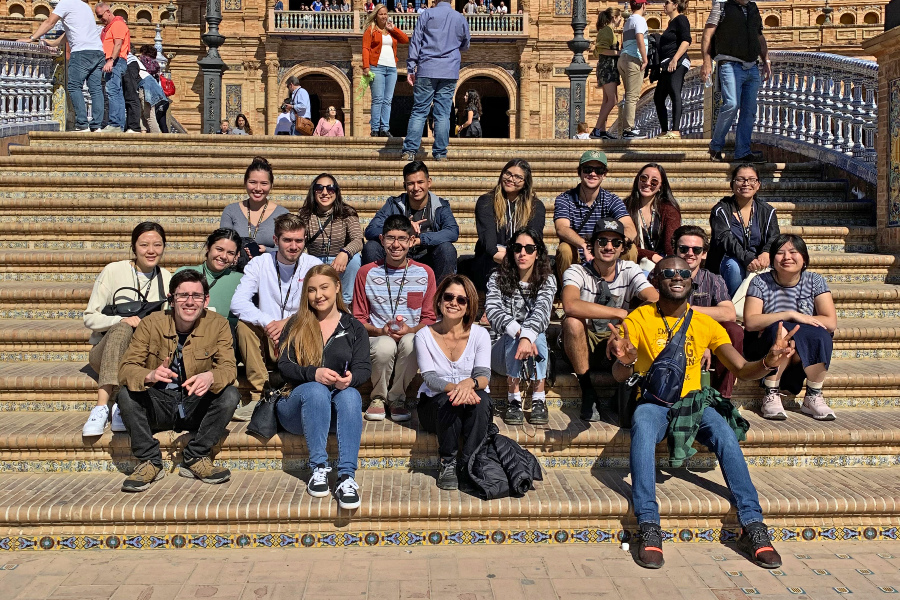 Study Abroad students sitting on the steps of a landmark in Spain