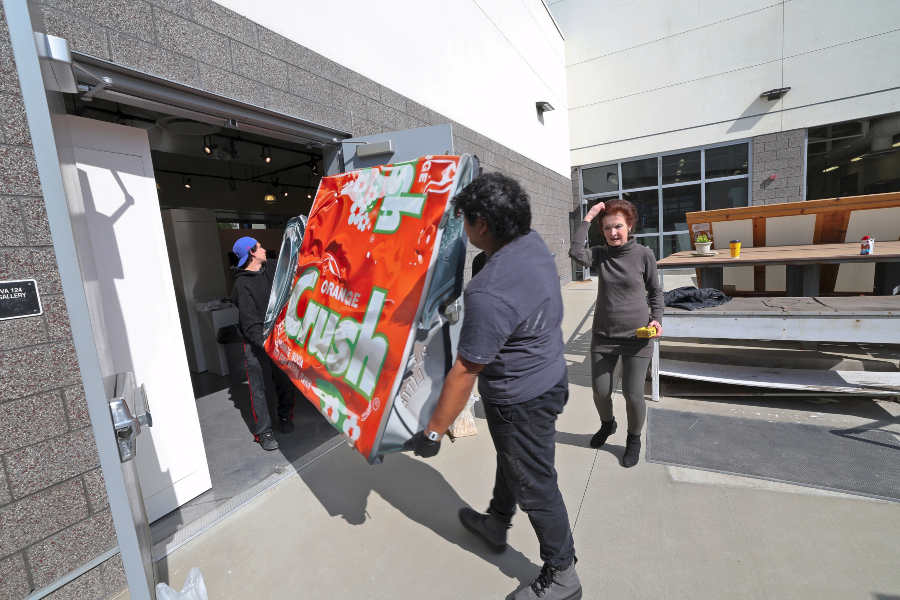 special installers carefully moving the pop art pieces into the college's art gallery