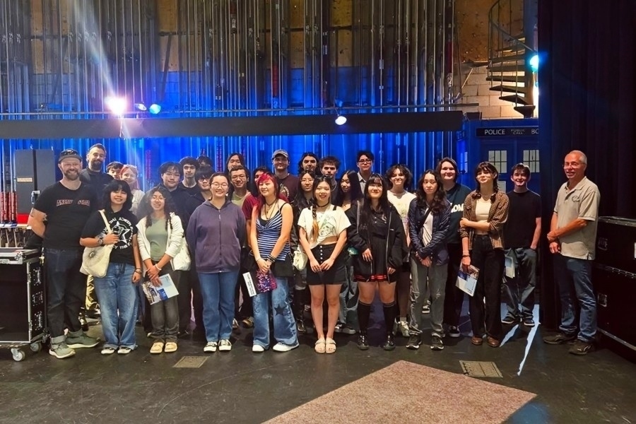 arcadia high school students gather onstage at the haugh performing arts center with theatrical lighting, fly-system rigging and backstage equipment visible around them