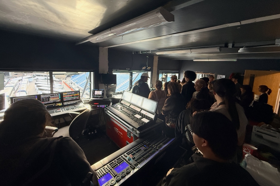 students and staff tour a technical control room overlooking the royal edinburgh military tattoo venue, surrounded by lighting, audio and production consoles