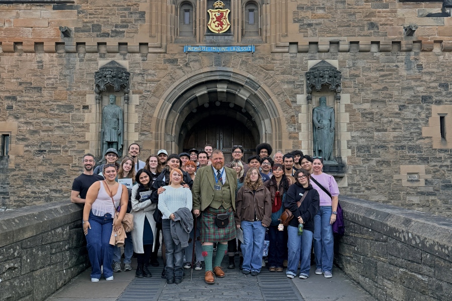 citrus college emerging theatre technologies students, faculty and staff pose with a guide outside the entrance to edinburgh castle in scotland