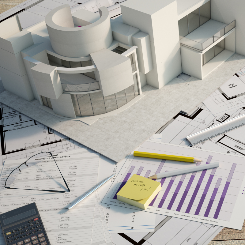 an architect's model of a contemporary building with blueprints and other tools of the trade sitting on a table top