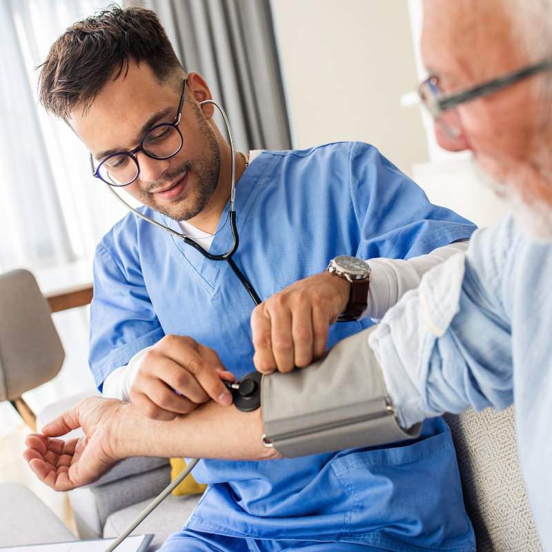male LVN taking an elderly patient's blood pressure