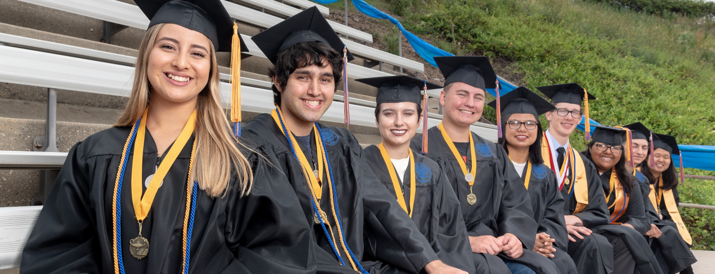 Honors graduates sitting in the college stadium during commencement rehersal