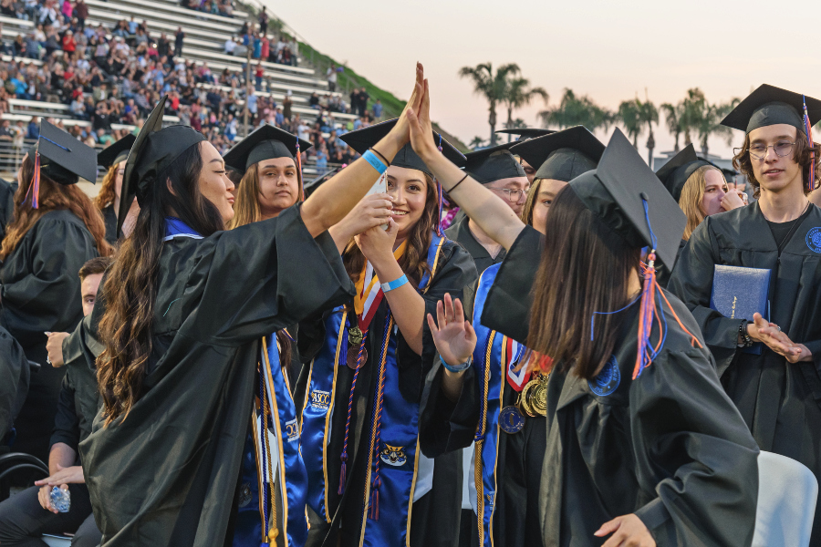 Citrus College grads celebrate with high fives after the ceremony