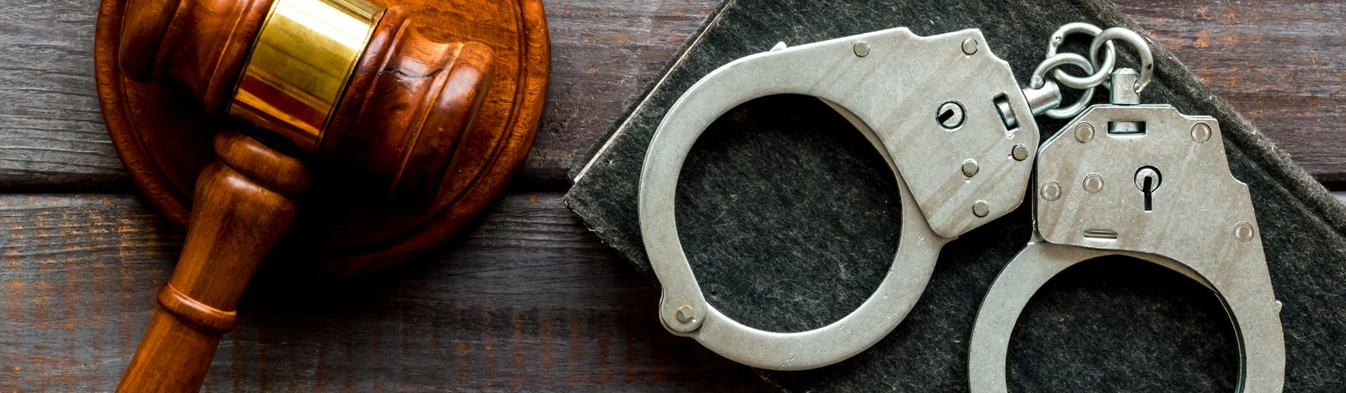 close-up of a gavel, and handcuffs sitting atop The Good Book