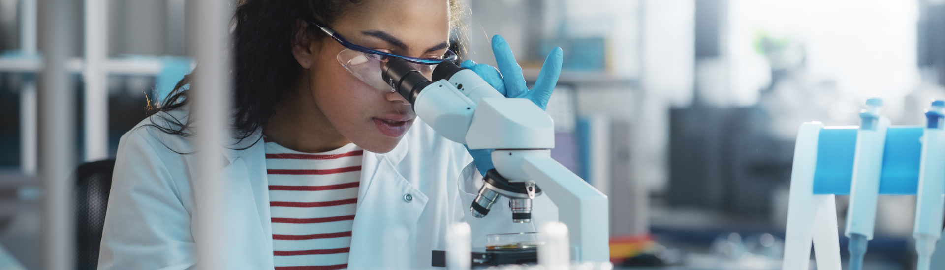 female student looking through microscope