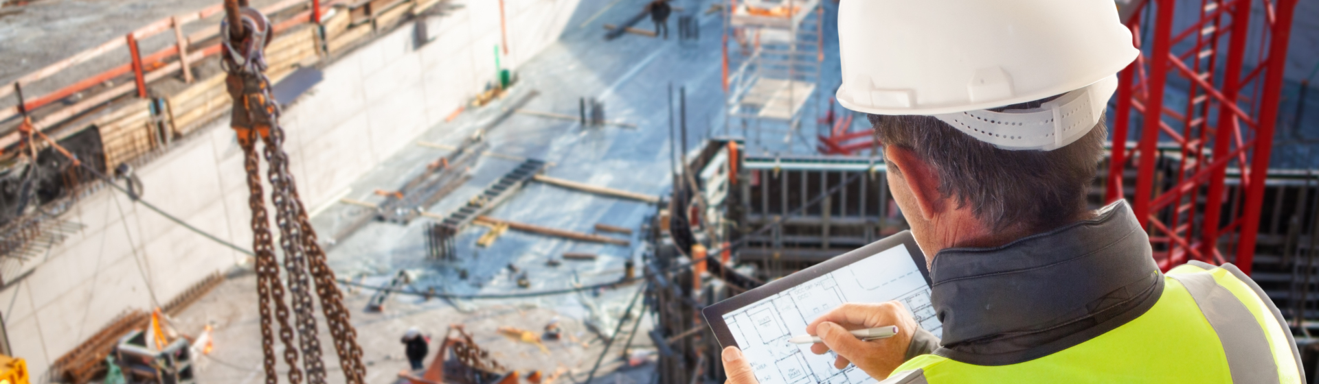 construction foreman with tablet and stylus surveying a construction site