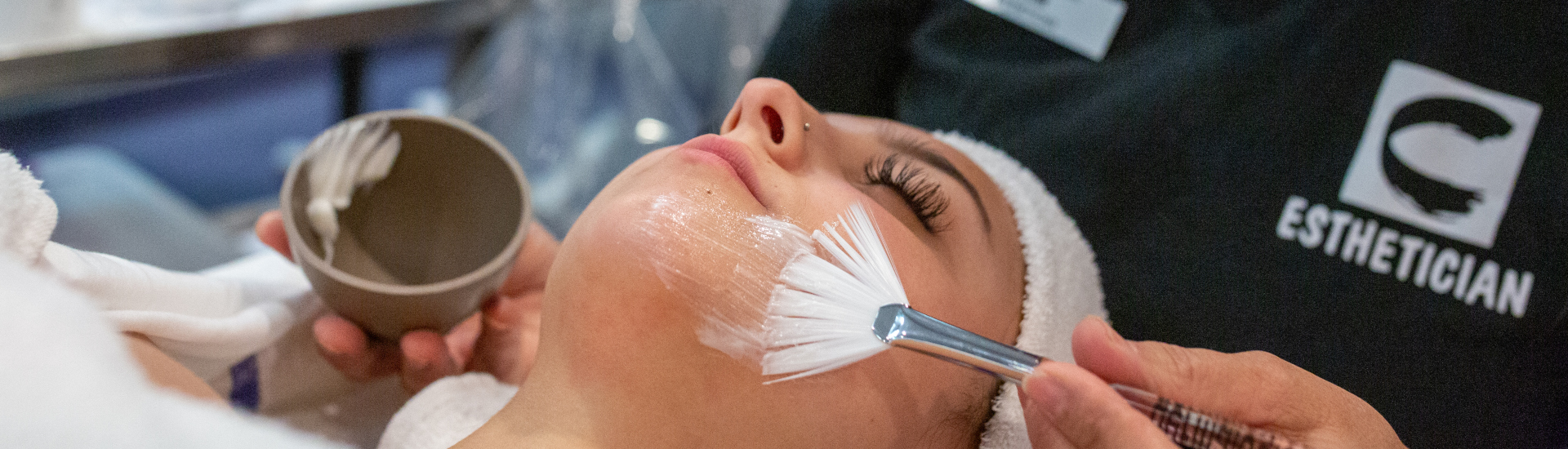 student esthetician applying a masque on a patron