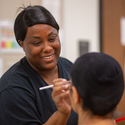 student esthetician applying make up on a client