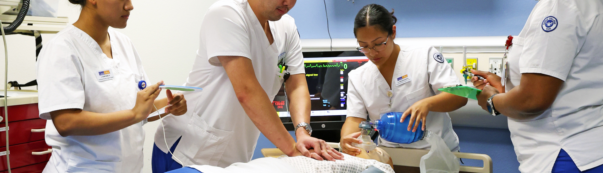 Nursing students in class performing resuscitation on a training manekin 