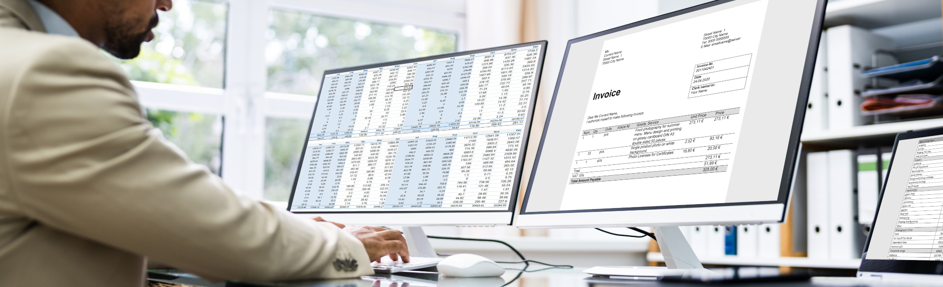 man with two computer monitors utilizing spreadsheet and billing software