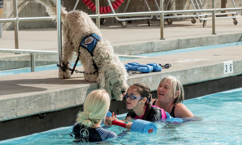 aquatics instructor and assistant with a KIN 148 student and her service dog