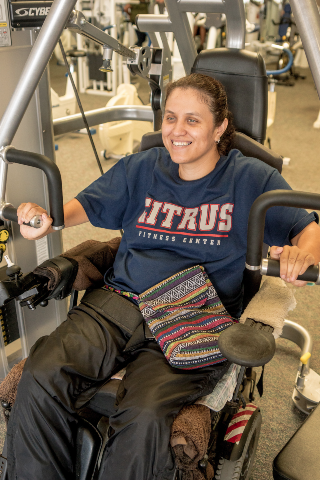 a Citrus College student at a wheelchair-accessible weight-training machine