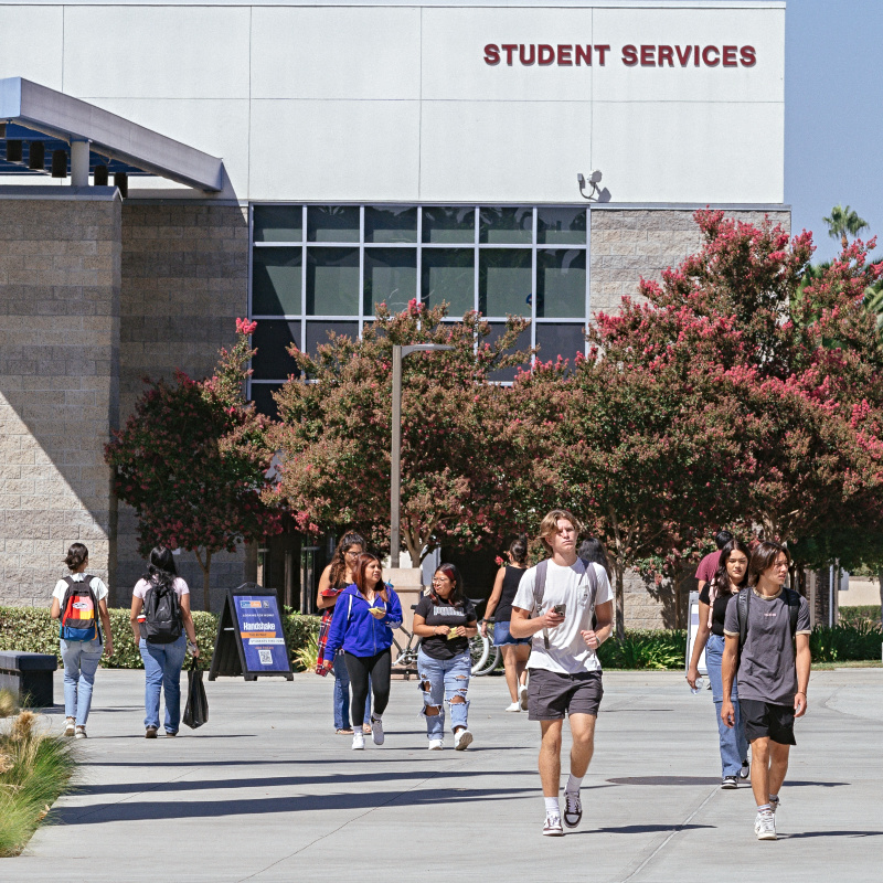 a number of first time college students walking away from the Student Services Building