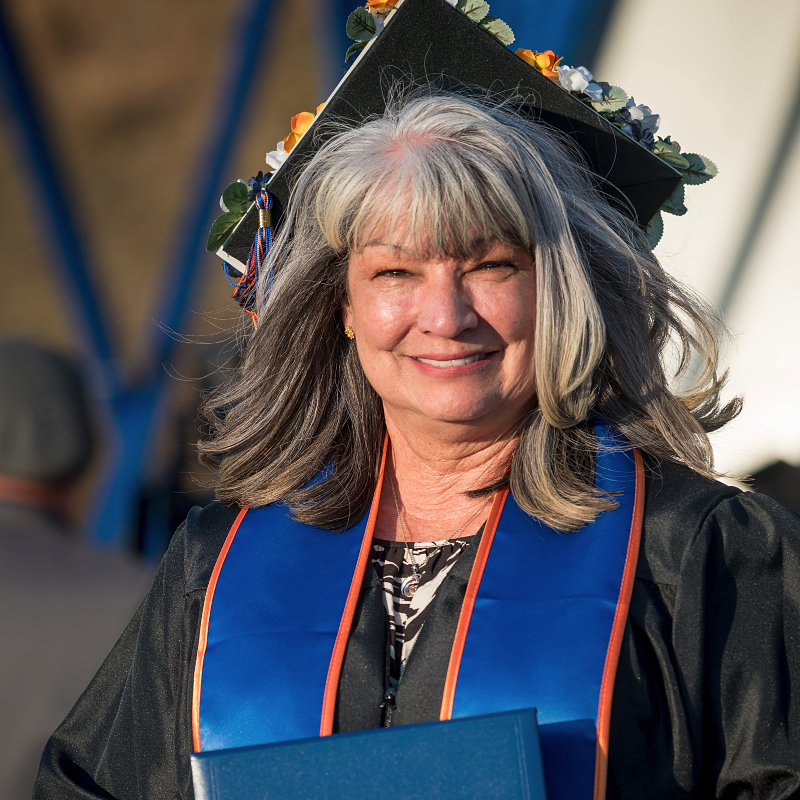 a mature female Citrus College graduate with her diploma as she walks off the stage at commencement