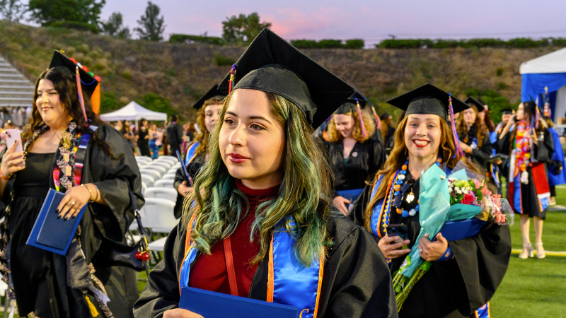 group of recent graduates in cap and gown