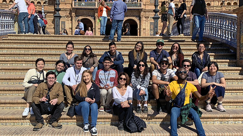 Study Abroad students sitting on the steps of a landmark in Spain