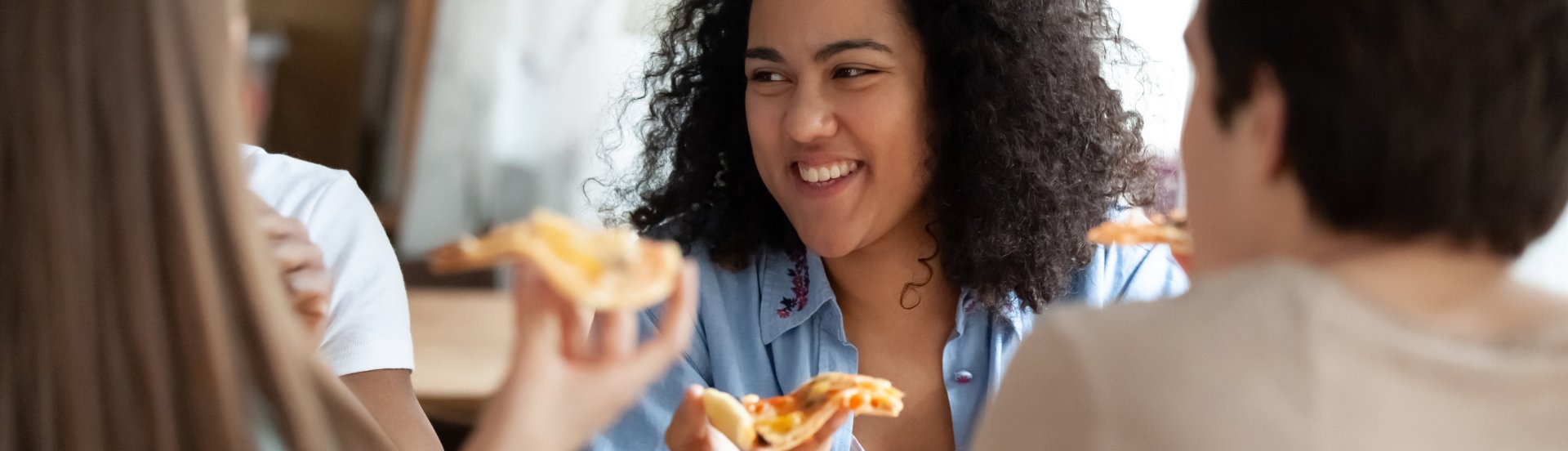 close-up of students enjoying a slice of pizza
