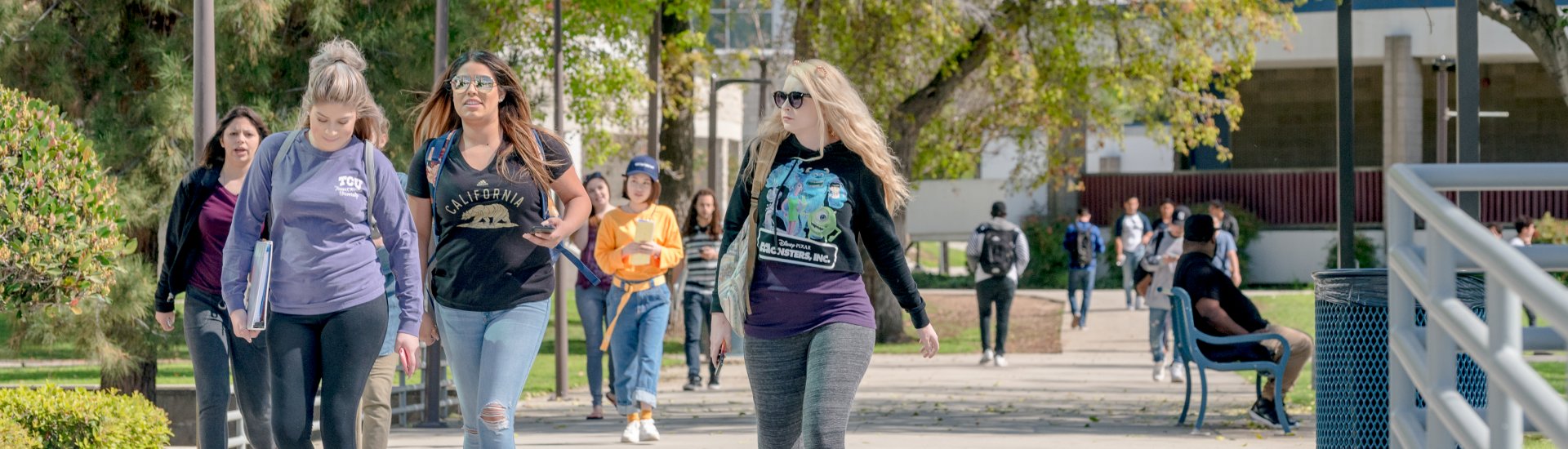 Students walking on campus, the Lecture Hall building in the background