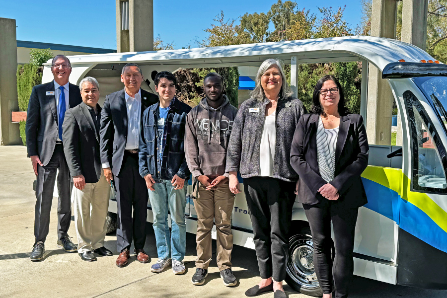 group of people standing in front of a transit vehicle during a GoPass campus event
