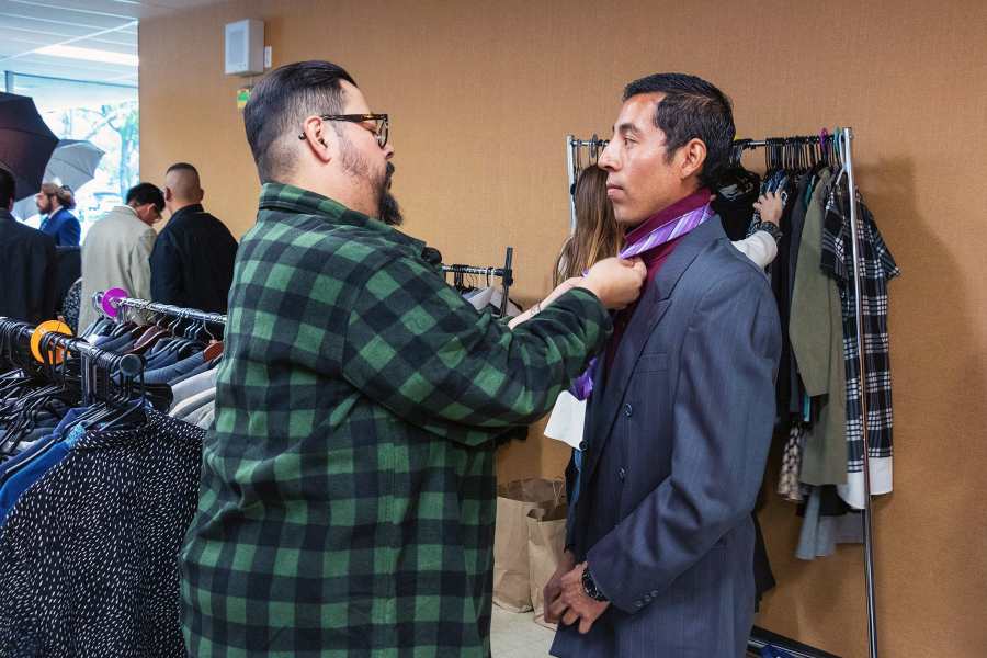 student getting help selecting a tie during a professional clothing event