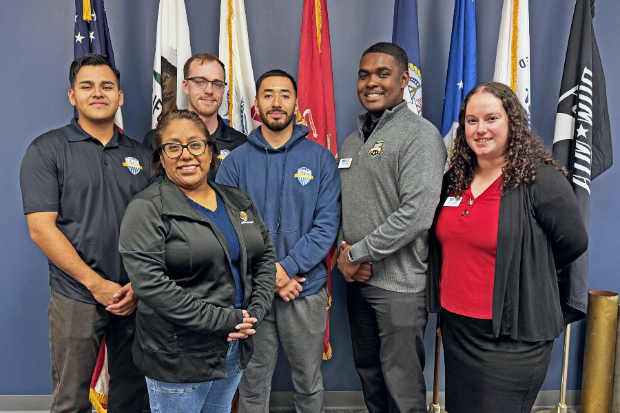 veterans success center staff stand in front of military service flags at citrus college