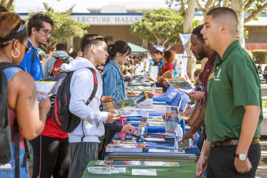 students gather at campus center mall tables to speak with university representatives during the citrus college fall transfer fair