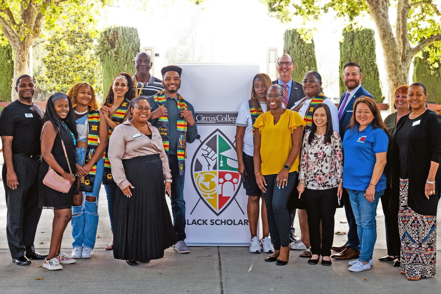 a group of staff and administrators with the Black Scholars banner 