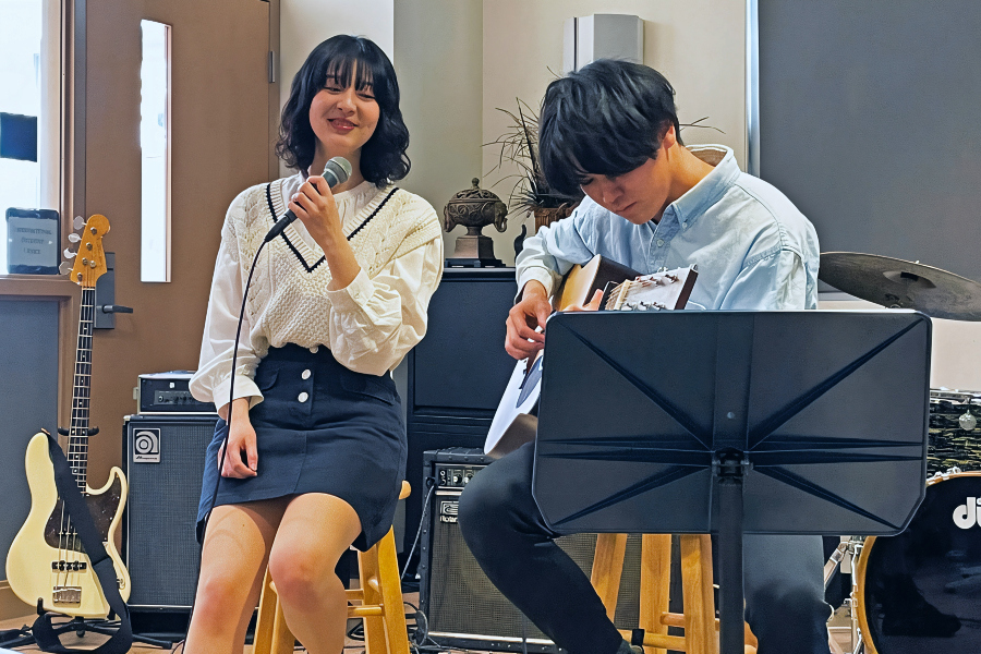 two international students, Izumi and Yuto, singing and playing guitar