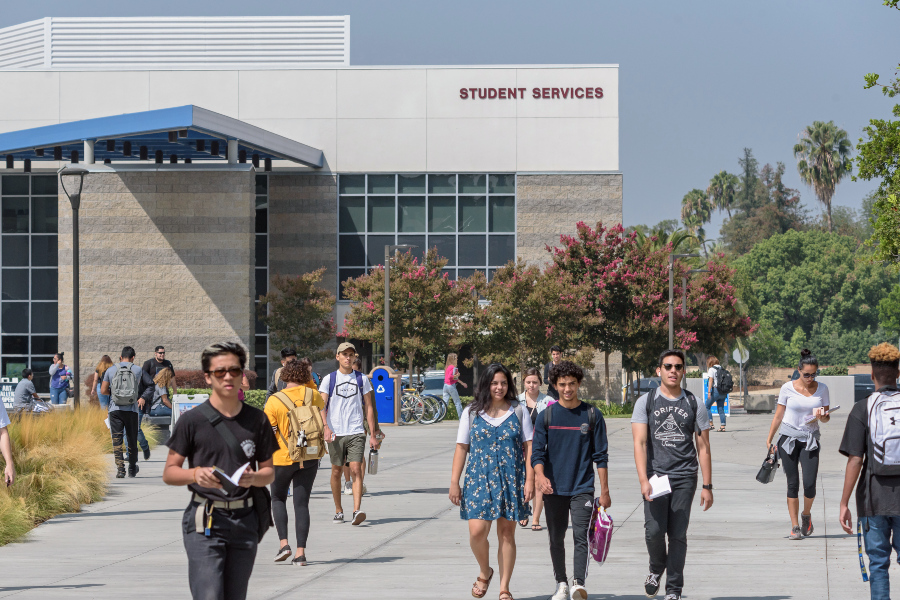 students walk across the citrus college campus in front of the citrus college student services building