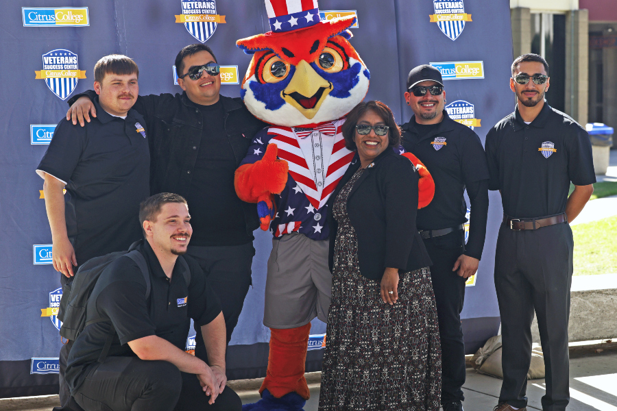 veterans success center staff pose with citrus college mascot, hootie, during a citrus college veterans event