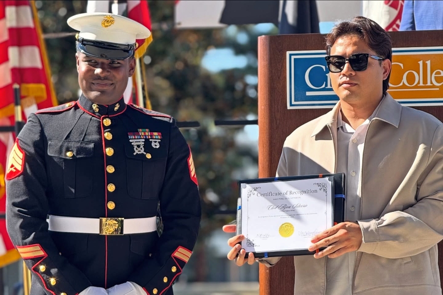 a u.s. marine in dress uniform stands beside a man holding a framed certificate of recognition during citrus college's saluting our veterans ceremony