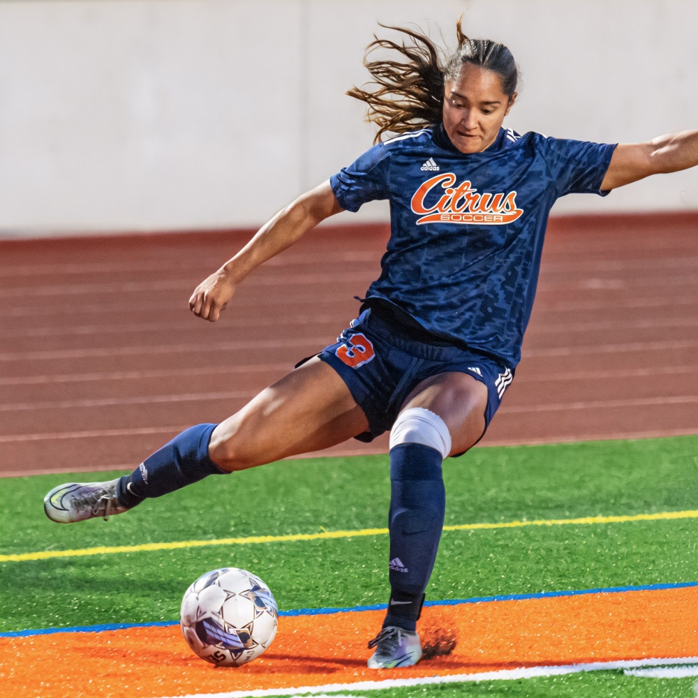 a citrus college soccer player kicks the ball near the sideline during a match