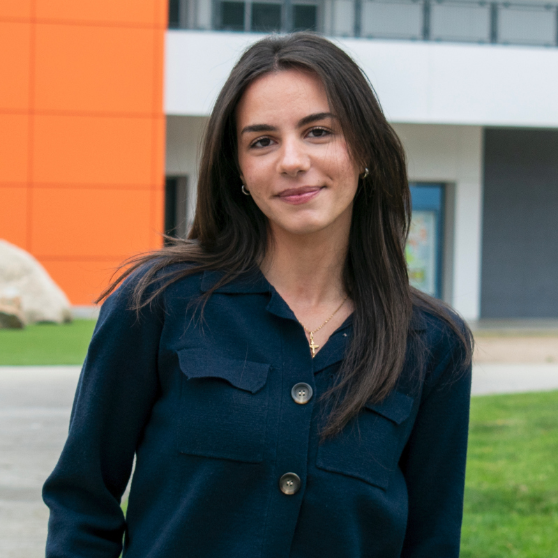 photo of Celine Ama standing in front of the college's ED Building