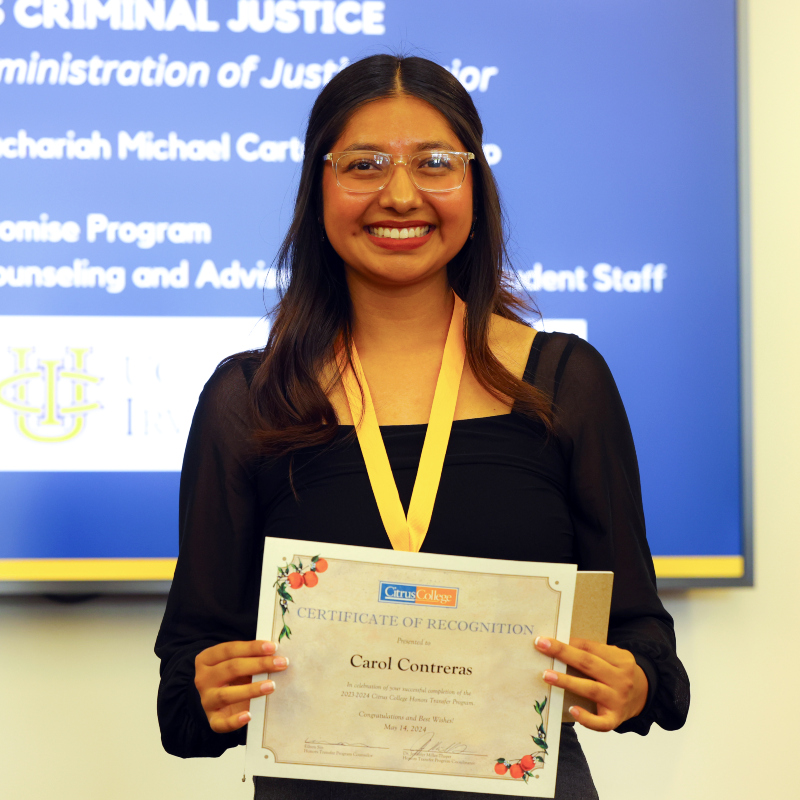 Carol Contras holding a certificate of recognition award