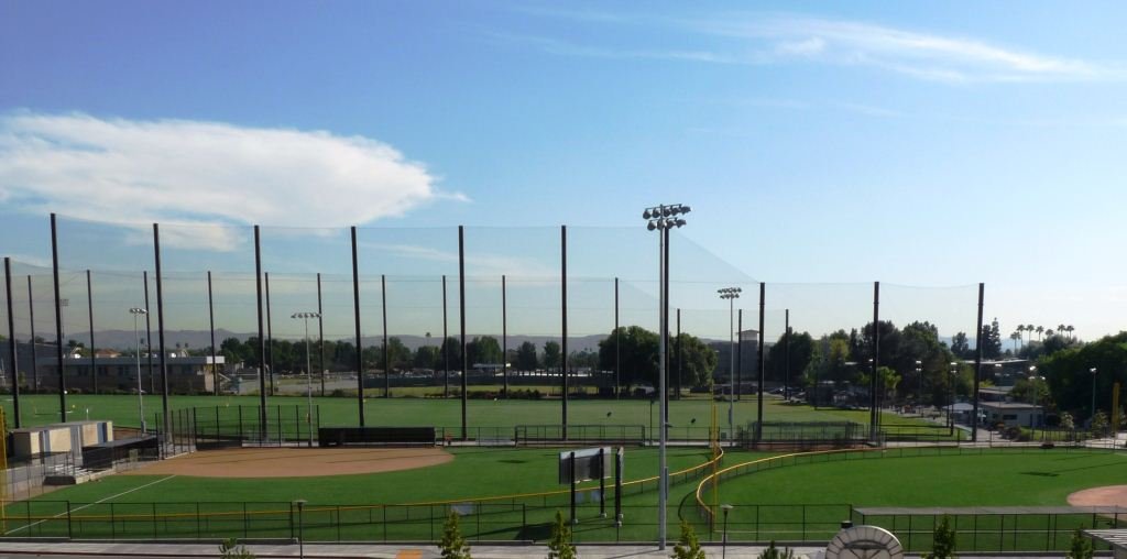 Softball fields in foreground with adjoining golf driving range in background